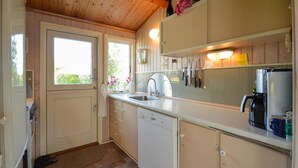 A compact kitchen with a dishwasher, a coffee maker, and a refrigerator. - Beach front home in Stubbekøbing (Stubbekøbing)