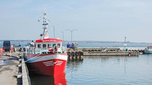 A red and white boat docked at a pier with a clear view of the water and distant shoreline. - Beach front home in Stubbekøbing (Stubbekøbing)