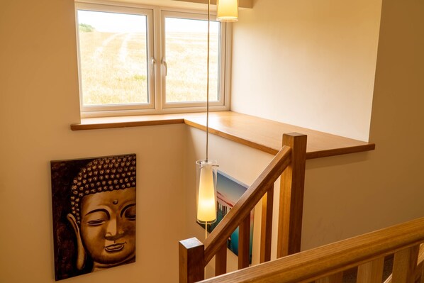 A staircase with wooden railings and a window above. - Bluebell Cottage - Two bedroom property with hot tub, close to the beach. (Ulverston)