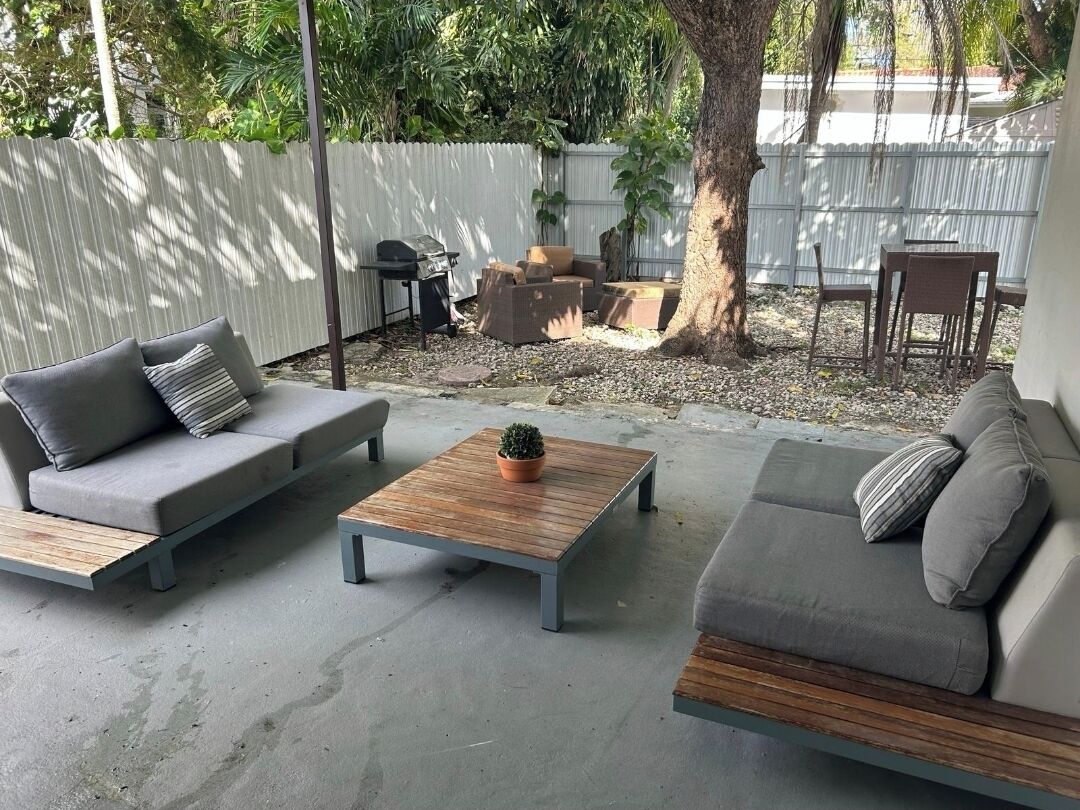 Eine Terrasse mit zwei Sofas, einem Couchtisch und einer kleinen Topfpflanze.