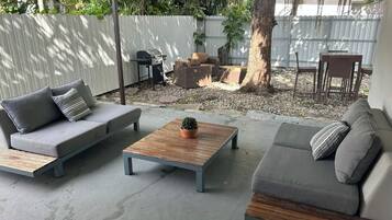 Eine Terrasse mit zwei Sofas, einem Couchtisch und einer kleinen Topfpflanze.