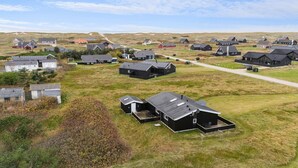 An aerial view of a rural area with multiple houses, some with attached garages, and a clear sky.