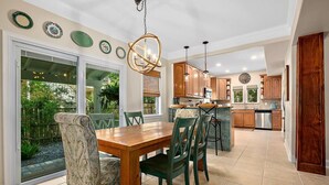 A kitchen with a dining area, large windows, and a view of the outdoors. - Casa DeSoto - Luxury Downtown Oasis (St. Augustine)