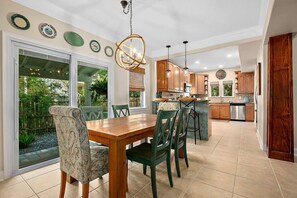 Une cuisine avec un coin repas, de grandes fenêtres et une vue sur l’extérieur.