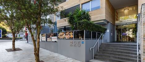 A modern building with a staircase leading to an entrance labeled "225".