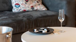 Een ronde tafel met sushi en een glas wijn.