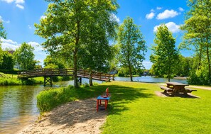 A park with a wooden bridge, a picnic table, and a playground.