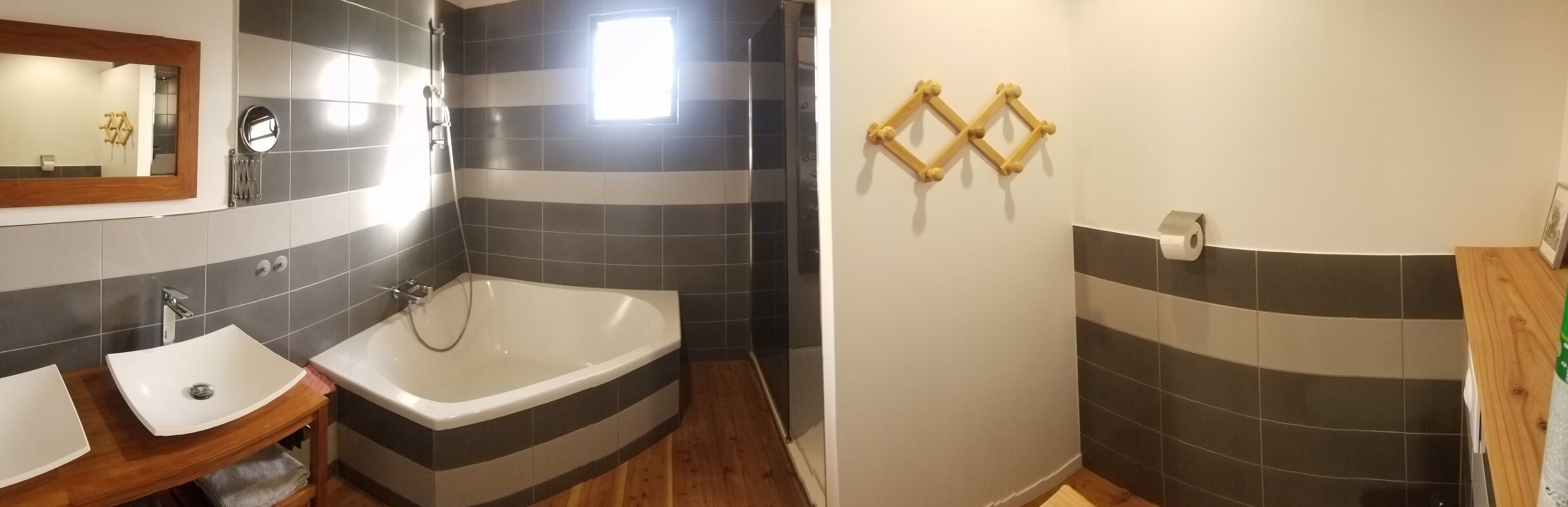 Een badkamer met een bad, een wastafel en een spiegel.