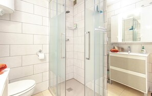 A modern bathroom with a glass shower enclosure, a toilet, a sink with a mirror, and a towel rack. - Gorgeous apartment in Torrevieja (Torrevieja)
