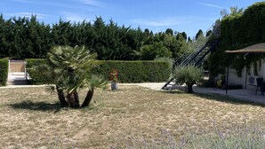 A garden with a palm tree, lavender, and a hedge. - Gîte Dipladenia with pool (Saint-Rémy-de-Provence)