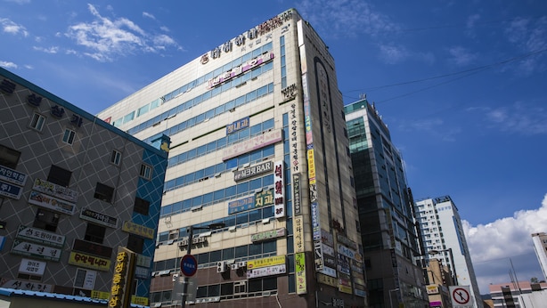 Un edificio de varios pisos con varios rótulos y anuncios en su fachada.