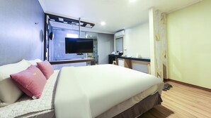 Una habitación de hotel con cama, televisión, escritorio y baño.