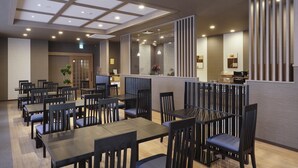 A restaurant with multiple tables and chairs, a counter area, and a ceiling with recessed lighting. - Hotel Route Inn Shinano Omachi Ekimae (Omachi)