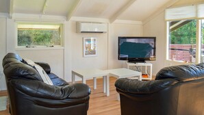 A living room with two leather sofas, a white coffee table, a flat-screen TV, and a small white side table. - 2 bedroom awesome home in Hals (Hals)