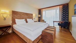 A hotel room with a large bed, bedside tables, a desk, and a chair. - Hotel Hafenspeicher - 14023 - Classic (Leer (Ostfriesland))