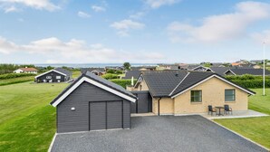 A residential area with houses, a gravel driveway, and a grassy lawn. - Cozy home in Vinderup with sauna (Vinderup)
