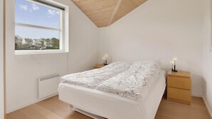 A bedroom with a bed, two bedside tables, a window, and a ceiling fan. - Cozy home in Vinderup with sauna (Vinderup)