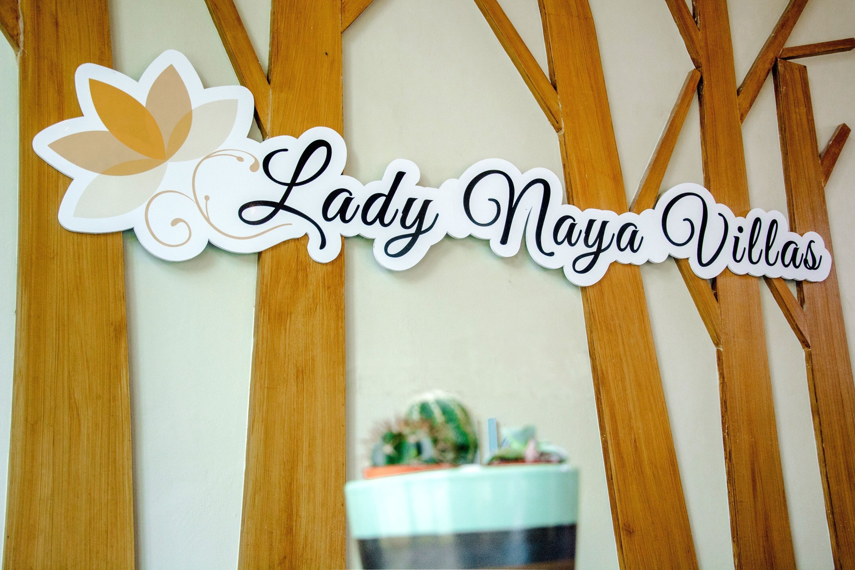 A sign with the text "Lady Naya Villas" and a decorative leaf design.