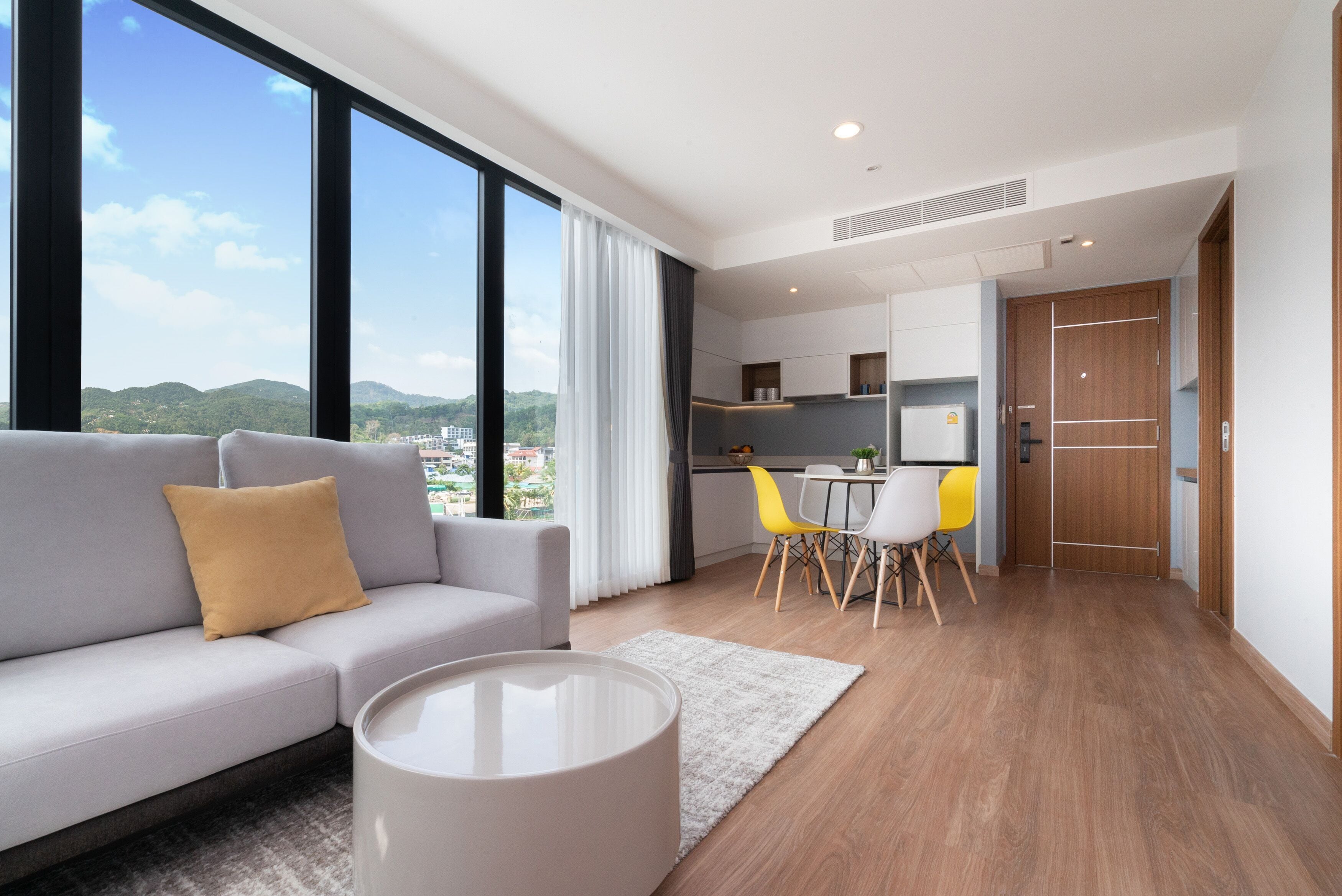 A modern living room with a sofa, a coffee table, and a view of the city.