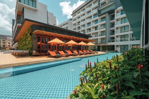A hotel with a swimming pool, sun loungers, and umbrellas. - Wekata Luxury (Karon)