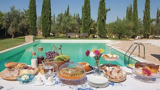 A poolside breakfast setup with various food items and drinks. - Cozy home in Chiaramonte Gulfi (Chiaramonte Gulfi)