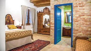 A bedroom with a bed, a mirror, a wardrobe, and a bathroom visible through an open door. - Cozy home in Chiaramonte Gulfi (Chiaramonte Gulfi)