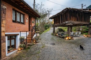 A rustic building with a stone facade, a wooden porch, and outdoor seating.