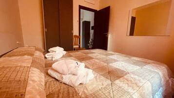 A hotel room with a bed, a wardrobe, and a mirror on the wall.
