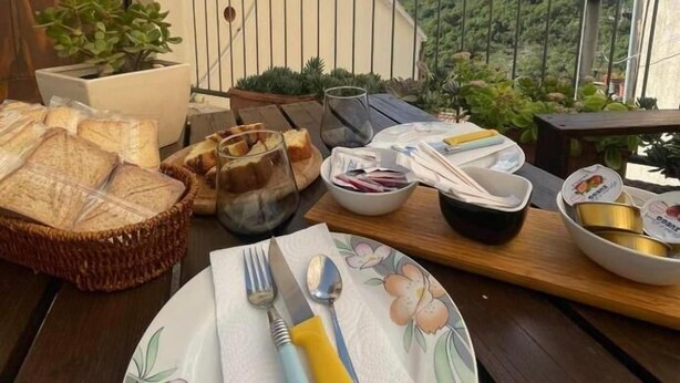 A balcony with a table set for breakfast, including bread, eggs, and utensils. - Da Nonna Pasqualina (Ciorlano)