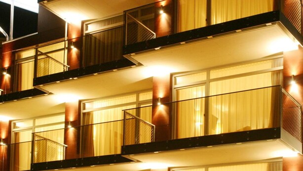 Un hotel de varios pisos con balcones y ventanas amplias.