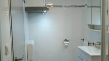 A modern bathroom with a toilet, sink, and mirror.