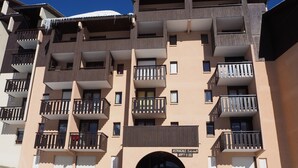 A multi-story hotel with balconies, an entrance with steps, and a sign indicating "ASTRAGALE Entrée." - Functional studio in Menuires, close to slopes, balcony (Les Menuires)