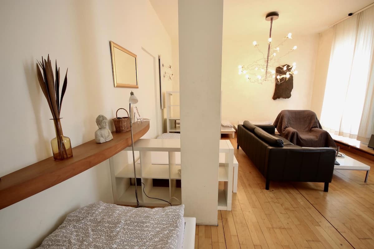 A modern living room with a sofa, a coffee table, and a wooden floor.