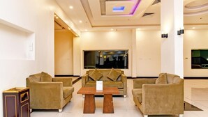 Eine Lobby mit einer Sofagarnitur, einem Couchtisch und einem großen Fenster.