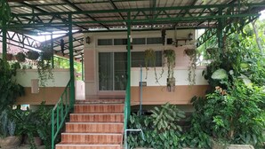 A covered outdoor area with a wooden staircase leading to a building entrance. - Rattikanchana Resort (Mae Fa Luang)