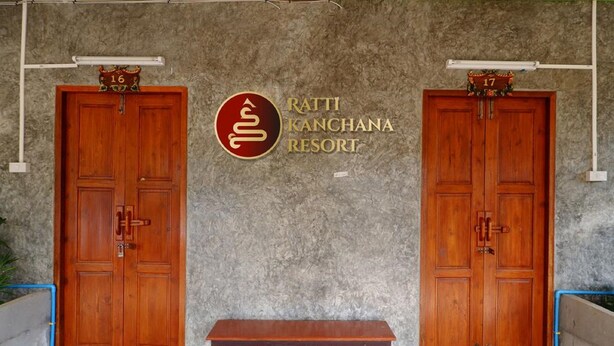 Two wooden doors with numbers 16 and 17 above them, a bench in front, and a wall with the text "Ratti Kanchana Resort". - Rattikanchana Resort (Mae Fa Luang)