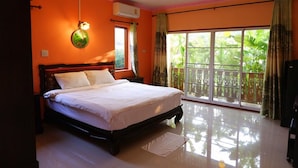 A bedroom with a large bed, an air conditioning unit, a window with curtains, and a view of greenery outside. - Rattikanchana Resort (Mae Fa Luang)