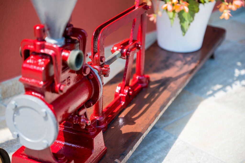 A red mechanical device on a wooden surface.