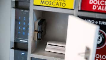 A vending machine with a numeric keypad and a coin slot, surrounded by various signs including "PIEMONTE MOSCATO" and "DOLCE D'ALBA".