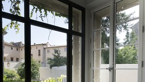 Ein Zimmer mit großen Fenstern, einer Tür und einem Fliesenboden.