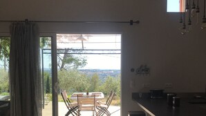 Een keuken met een schuifdeur die uitkomt op een terras met een tafel en stoelen.