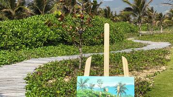Un cavallet amb una pintura d'un paisatge tropical, envoltat de verdura exuberant i palmeres.