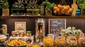 A buffet with various food options including fruit salad, cornflakes, and granola. - Motel One Bonn-Hauptbahnhof (Bonn)