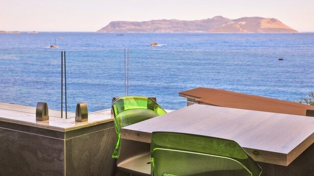 A terrace with a view of the sea, featuring a table and two chairs. - Zeytin Hotel (Kas)