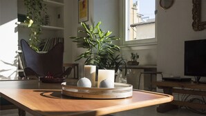 A wooden table with a tray holding two candles and a potted plant. - Charming apartment 2 bdrs in Brera district (Milano)