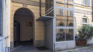 A building entrance with a large glass window, an archway, and a potted plant. - Charming apartment 2 bdrs in Brera district (Milano)