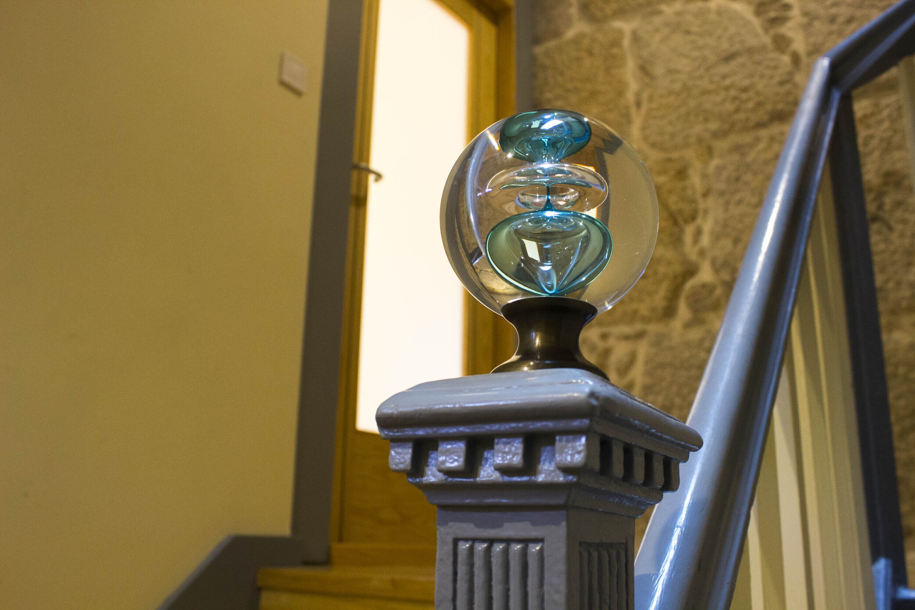 Una escalera con un globo de vidrio decorativo en la barandilla.