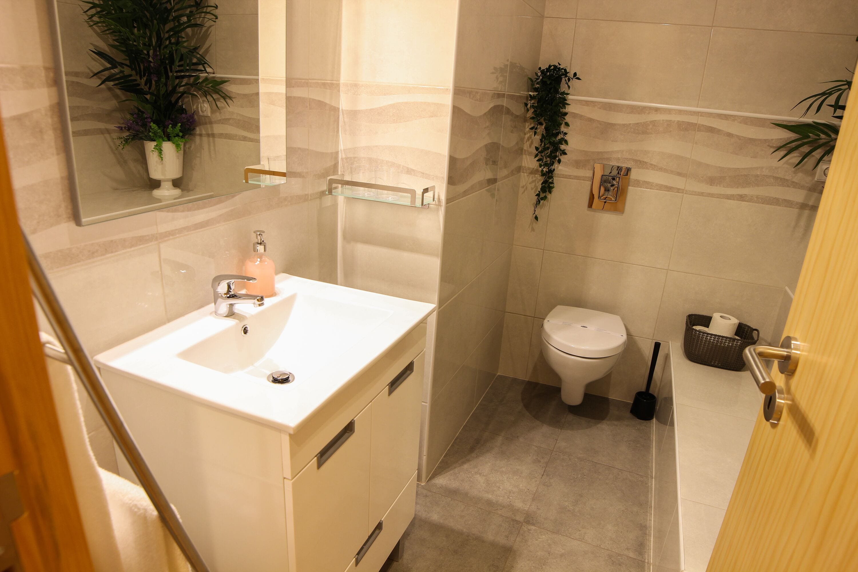 A bathroom with a sink, toilet, and a shower area.