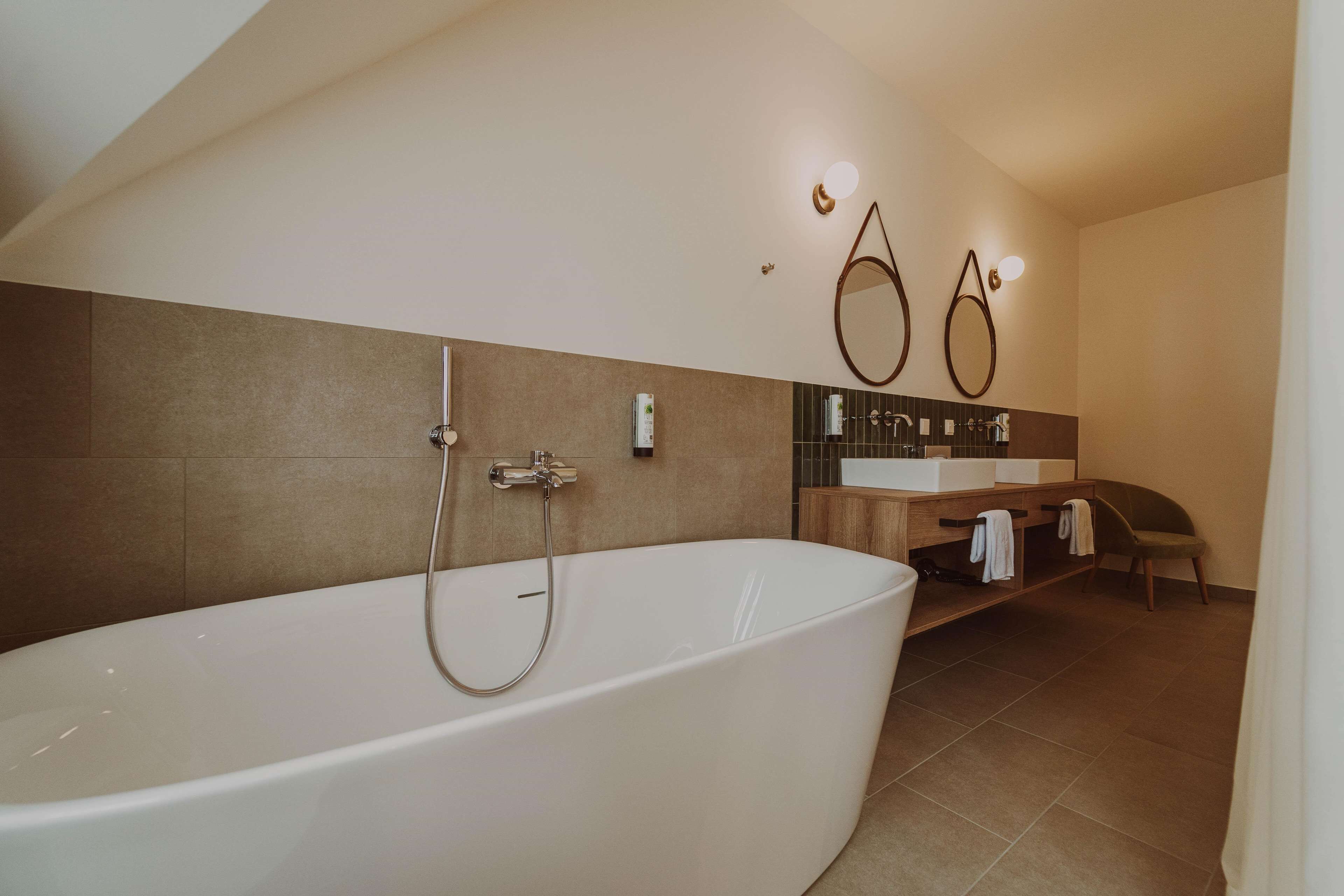Une salle de bain moderne avec une baignoire sur pieds, un meuble-lavabo avec un miroir et un espace douche.