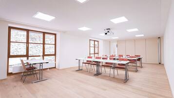 A conference room with a long table, multiple chairs, and a projector.